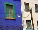 tinas azules del travesano de la ventana del verde de la pared